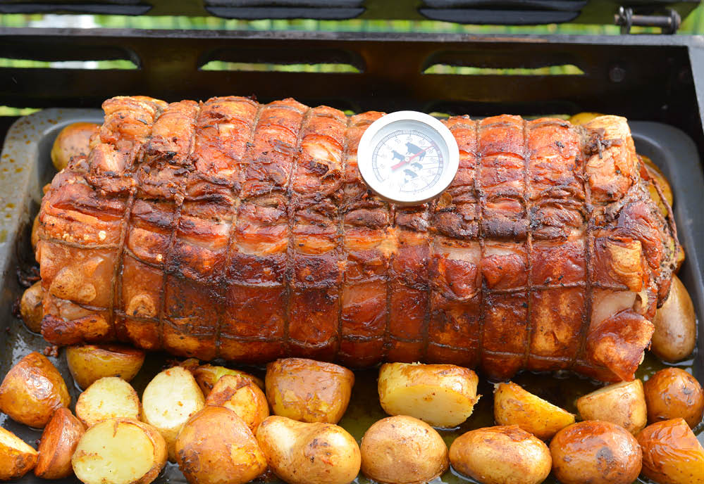 Cooked roast of pork or Italian porchetta recipe on a grill